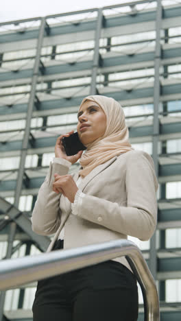 Vertikales-Video-Einer-Muslimischen-Geschäftsfrau-Mit-Mobiltelefon,-Die-Vor-Dem-Büro-In-Stadt-1-Steht